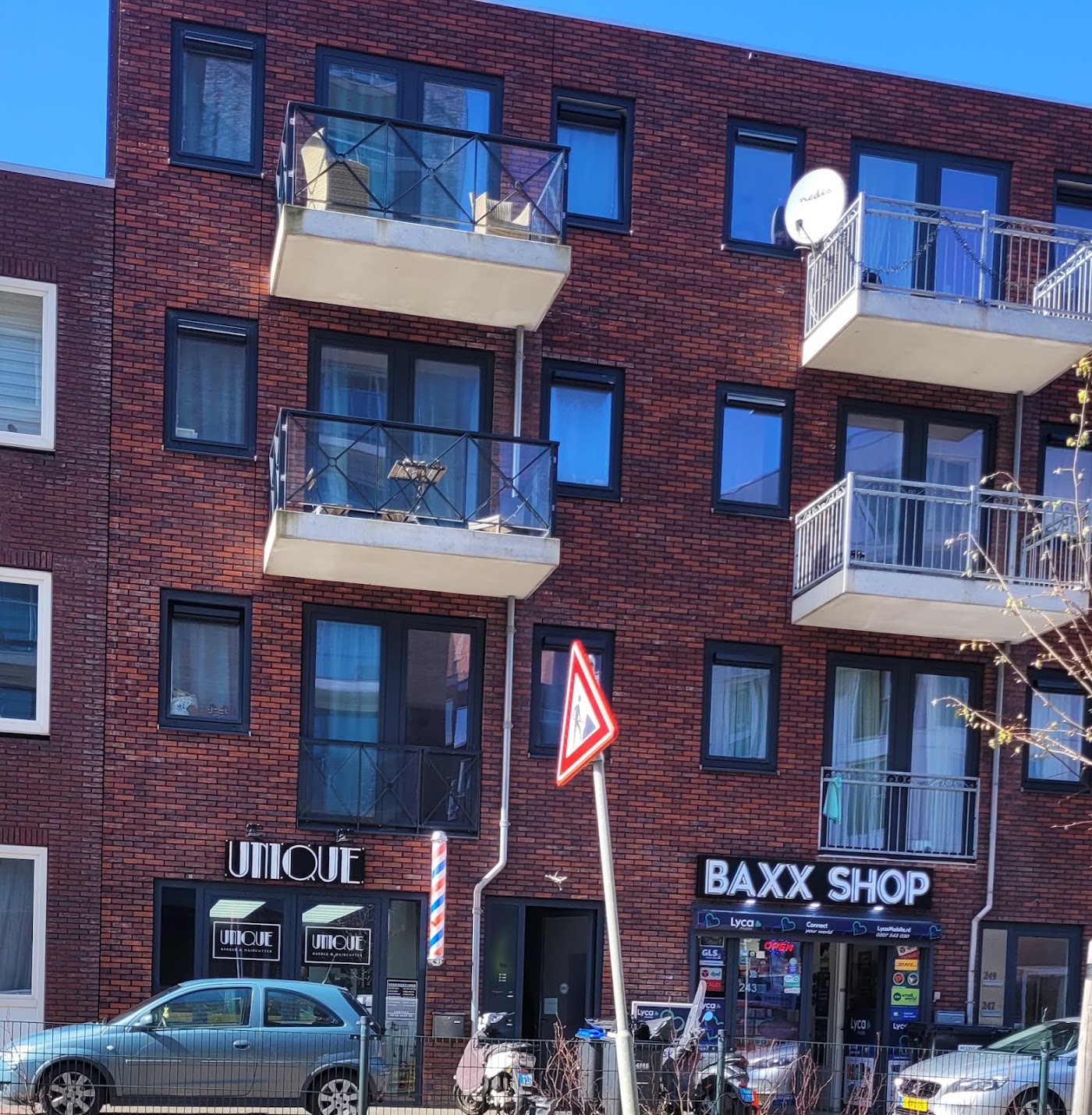 De gevel van Unique Barber aan de Waldorpstraat