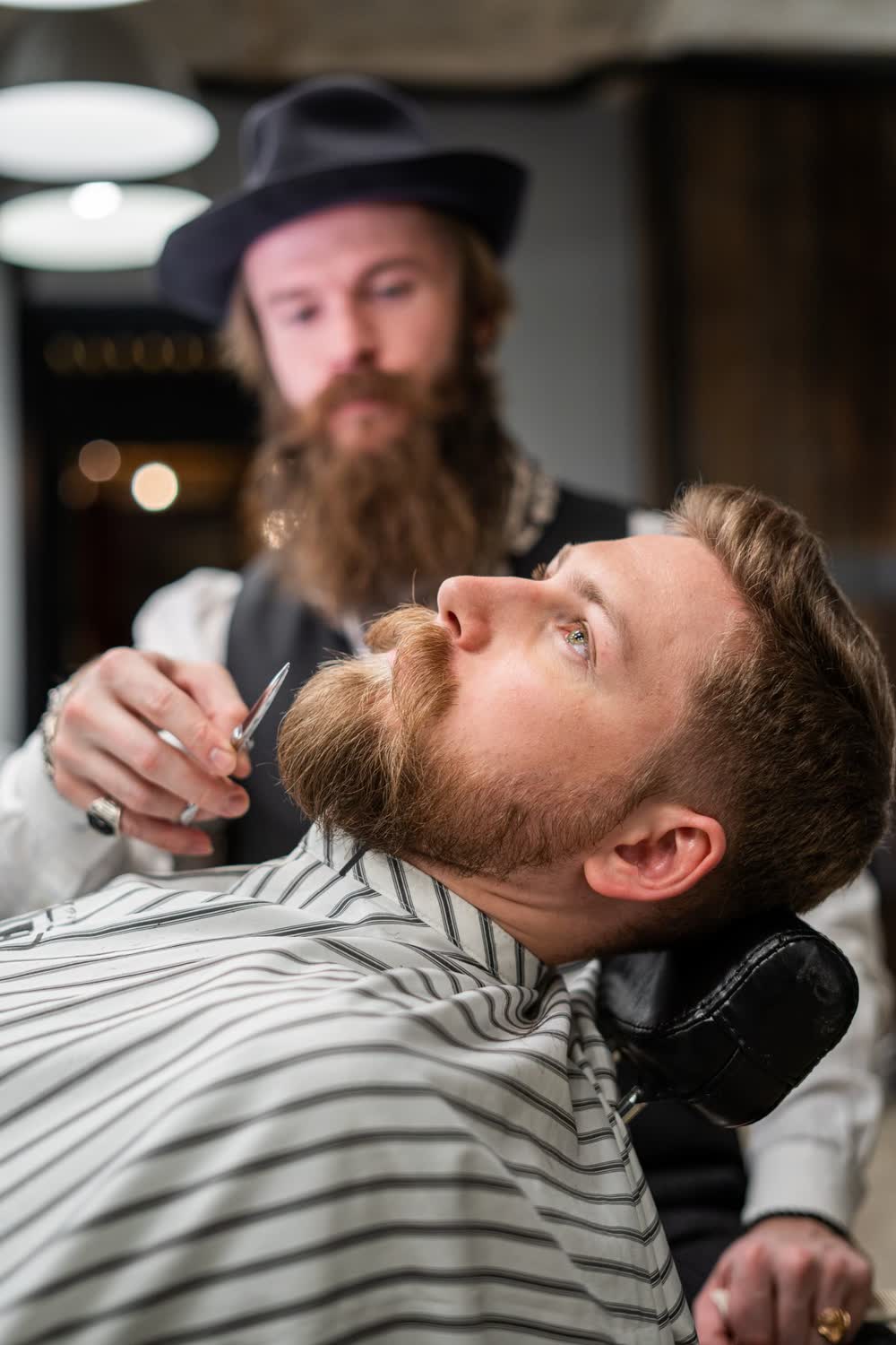 Barber maakt een klant klaar voor een scheerbeurt